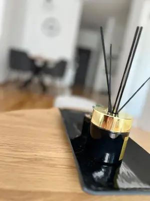 a black cup with sticks in it on a table at Apartman Relax in Arandjelovac