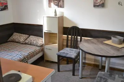 a small room with a table and a bed and a table and chair at Studio Apartman Grof in Belgrade
