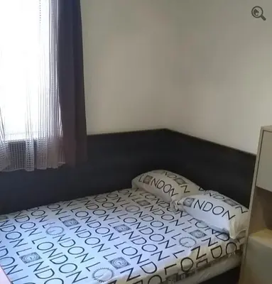 a small bed in a room with a window at Studio Apartman Grof in Belgrade