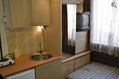 a small kitchen with a sink and a tv at Studio Apartman Grof in Belgrade