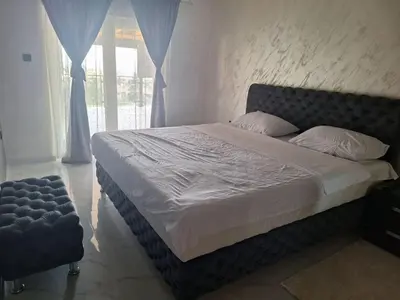 a bed in a bedroom with a large window at Apartmani Lux Filipovic in Smederevo