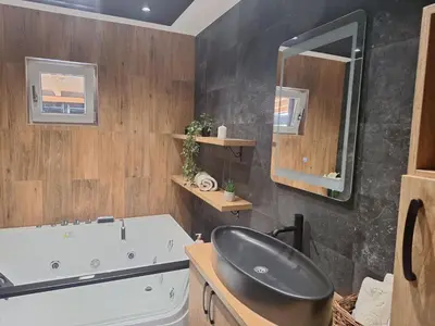 a bathroom with a white tub and a sink at Apartmani Lux Filipovic in Smederevo