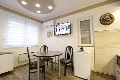 a dining room with a table and chairs and a tv at Studio Apartman Valdez 2 in Belgrade