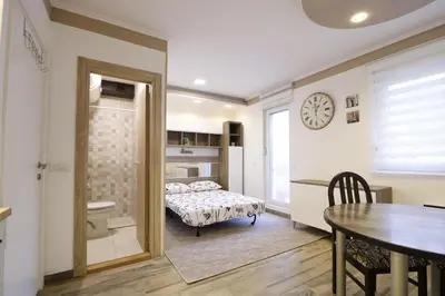 a bedroom with a bed and a table and a clock at Studio Apartman Valdez 2 in Belgrade