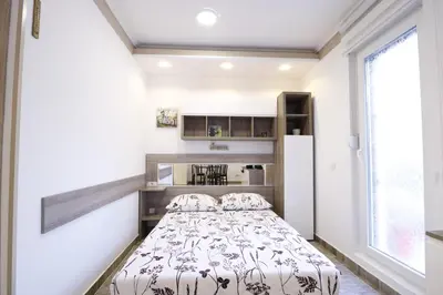 a small bedroom with a bed and a window at Studio Apartman Valdez 2 in Belgrade