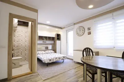 a bedroom with a bed and a table and a dining room at Studio Apartman Valdez 2 in Belgrade