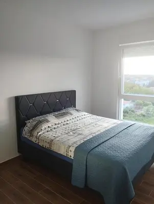 a bed in a white room with a window at Amare2 in Inđija