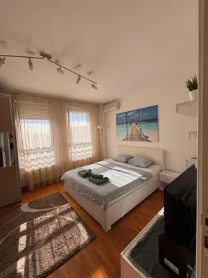 a bedroom with a bed and a flat screen tv at Belvil Belgrade in Belgrade