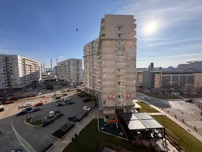 a tall building in a city with a parking lot at Belvil Belgrade in Belgrade