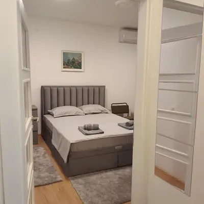 a bedroom with a bed and a closet at Sarina Garsonjera in Arandjelovac