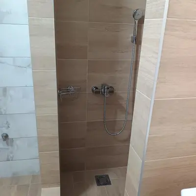 a shower in a bathroom with a glass door at Sarina Garsonjera in Arandjelovac