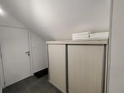 a bathroom with white towels on top of a closet at Nomad apartments in Belgrade