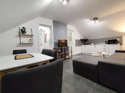 a kitchen and a living room with a table and chairs at Nomad apartments in Belgrade