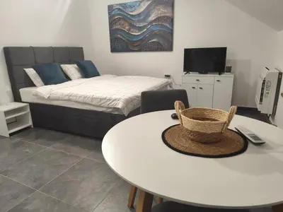 a room with a white table and a bed and a bed at Nomad apartments in Belgrade