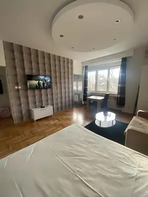 a bedroom with a bed and a flat screen tv at Skadarlija Square in Belgrade