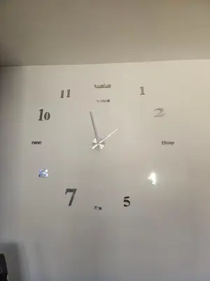 a white clock hanging on a wall at Apartman daba 1 in Belgrade