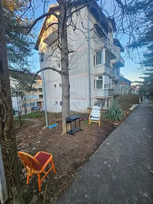 two chairs and a table in front of a building at Apartman daba 1 in Belgrade