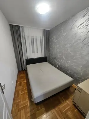 a small bedroom with a white bed in a room at Apartman daba 1 in Belgrade