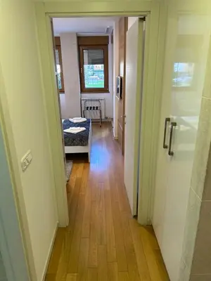 a hallway with a room with a table and a door at A Blok A12 in Belgrade