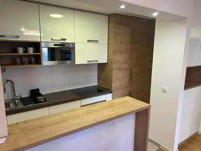 a kitchen with white cabinets and a wooden counter top at A Blok A12 in Belgrade