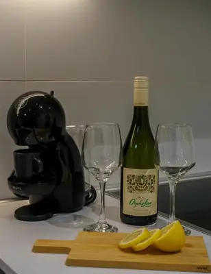 a bottle of wine and two wine glasses on a counter at BW Vista studio M&M - free parking in Belgrade