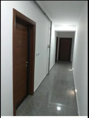 an empty hallway with a wooden door and a corridor at Simon in Karaburma