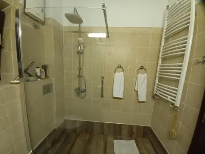 a bathroom with a tub and a shower with towels at Mirara in Belgrade