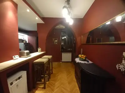 a kitchen with red walls and a counter with stools at Mirara in Belgrade