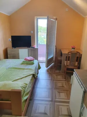 a room with a bed and a table and a television at Double Lux Aparrment A1 in Pancevo in Pančevo