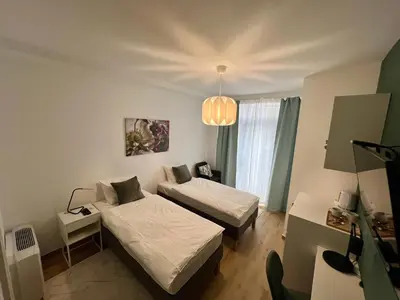 a small room with two beds and a chandelier at Ada Smart Apartment in Belgrade