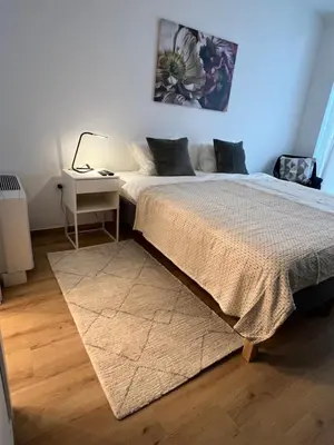 a bedroom with a bed and a nightstand with a table at Ada Smart Apartment in Belgrade