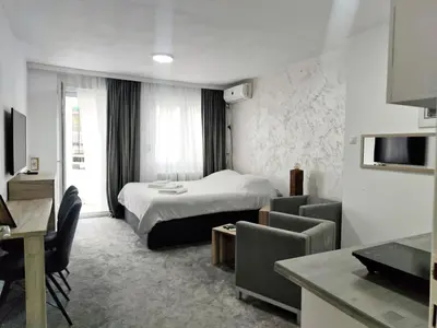 a hotel room with a bed and a living room at Open-space Apartment in the city center in Belgrade