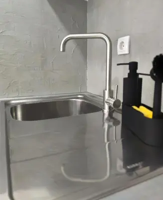a kitchen sink with a faucet on a counter at Open-space Apartment in the city center in Belgrade