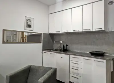 a kitchen with white cabinets and a sink at Open-space Apartment in the city center in Belgrade