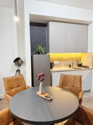 a kitchen with a table with a vase of flowers on it at ASTRA LUX - Galerija Beograd na vodi - Belgrade Waterfront in Belgrade