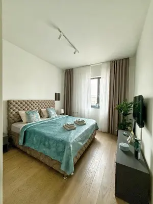 a bedroom with a large bed with a blue blanket at ASTRA LUX - Galerija Beograd na vodi - Belgrade Waterfront in Belgrade