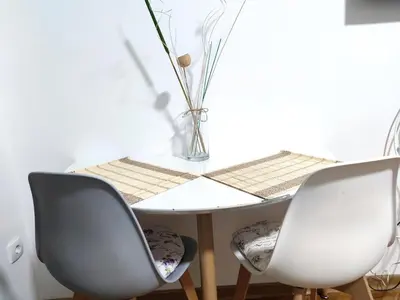 a table with two chairs and a vase on it at Boho-Style Apartment in the city center in Belgrade