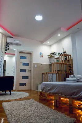 a bedroom with a bed and a room with a door at Boho-Style Apartment in the city center in Belgrade