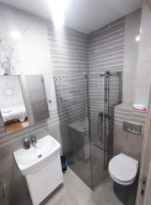 a bathroom with a shower and a toilet and a sink at Boho-Style Apartment in the city center in Belgrade