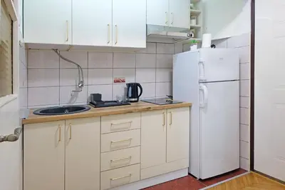 a kitchen with white cabinets and a white refrigerator at Safari Downtown Apartment in Belgrade