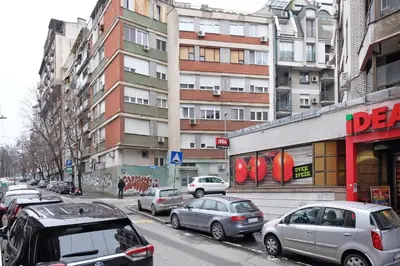 a busy city street with cars parked on the street at Safari Downtown Apartment in Belgrade