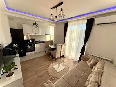a living room with a couch and a dining room at Lux apartment with a park view in Belgrade