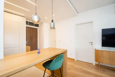 a kitchen with a wooden table and a green chair at Monza in Belgrade