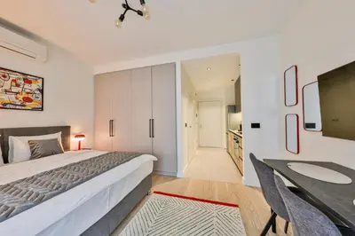 a bedroom with a bed and a table and a desk at ZIGZAG Belgrade Waterfront - SIMFONIJA 1 in Belgrade