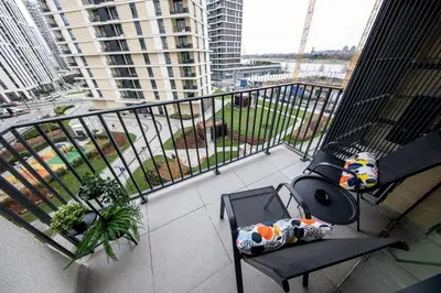 a balcony with a chair and a view of a building at ZIGZAG Belgrade Waterfront - SIMFONIJA 1 in Belgrade