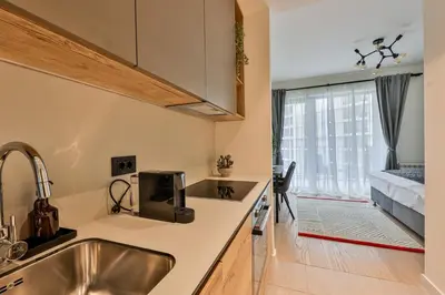 a kitchen with a sink and a window with a bed at ZIGZAG Belgrade Waterfront - SIMFONIJA 1 in Belgrade