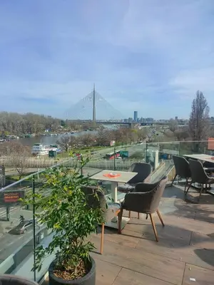 a patio with tables and chairs and a view of a bridge at Industrija in Belgrade