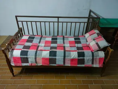 a bed with a plaid blanket and two pillows on it at Industrija in Belgrade