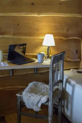 a desk with a laptop and a chair with a lamp at Zonamita house in Velika Remeta