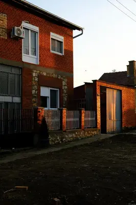 a brick house with a fence in front of it at Royal castle Fruska gora in Prnjavor
